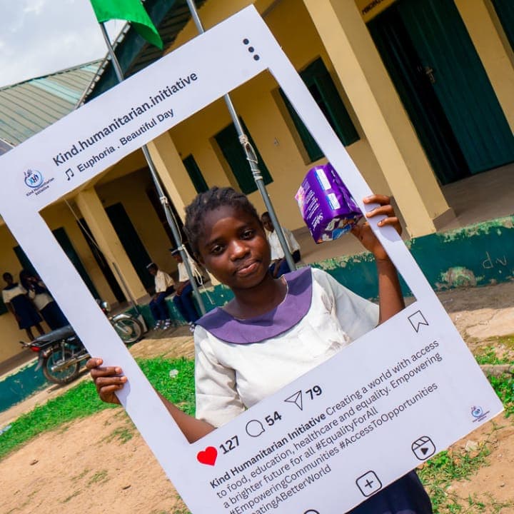 A student holding the KHI photo frame with a pack of sanitary pads